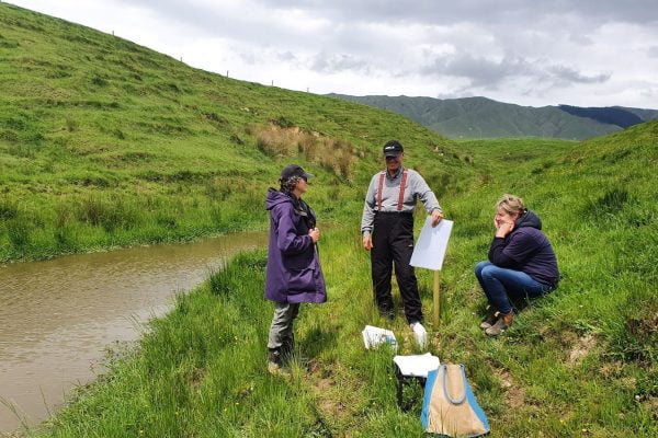 Christine Finnigan, Terry Parminter, and Kim Bills beside the Nguturoa Stream on the property of Kim and Peter Bills